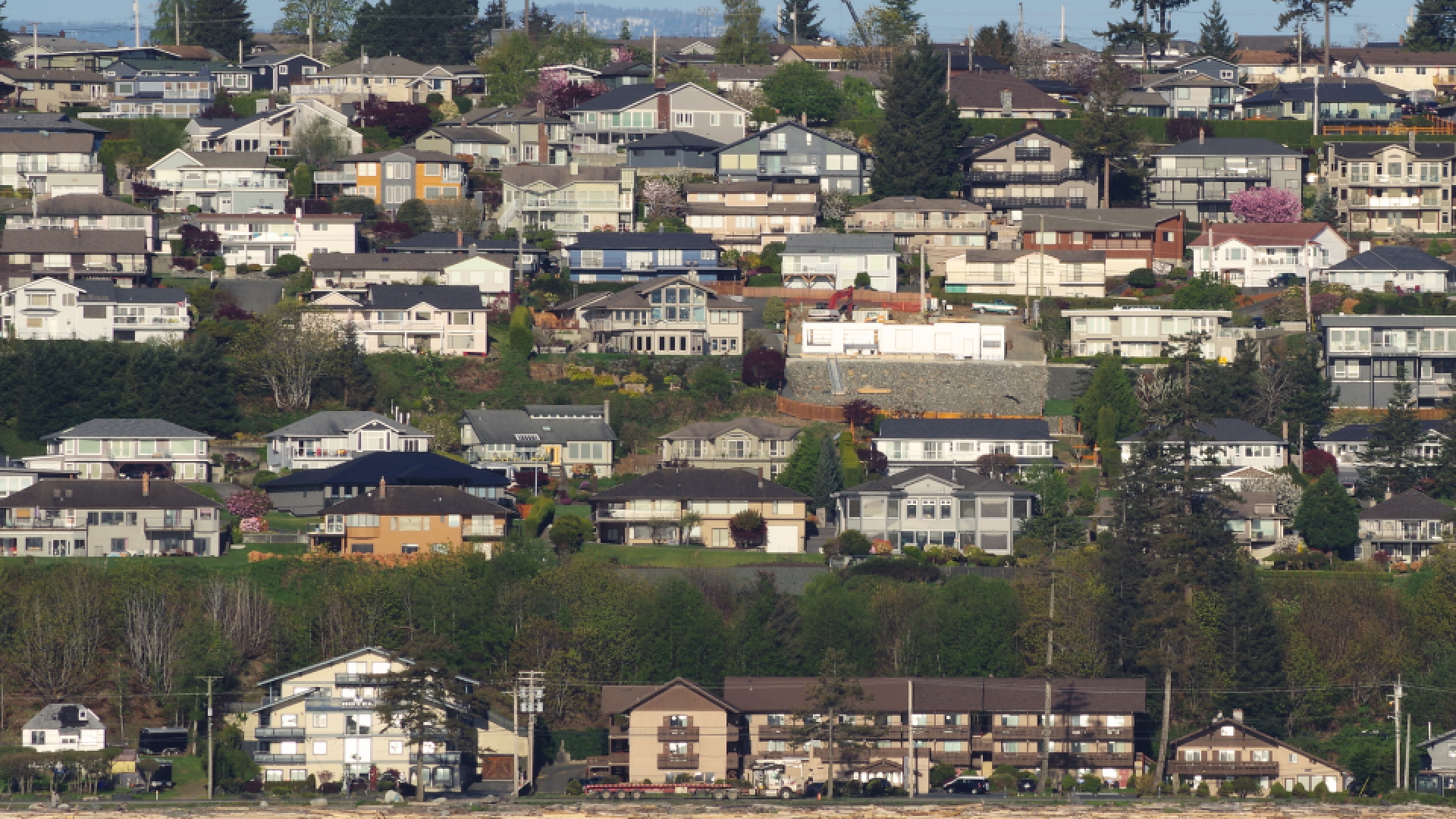 Rows of houses along a hillside and ocean