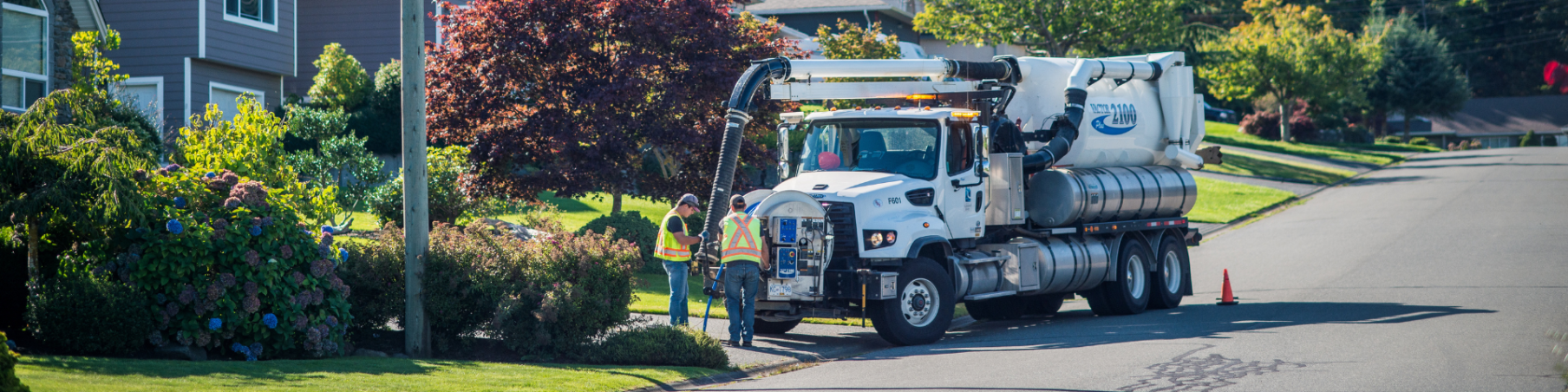 Two workers with vac truck monitoring sewer system