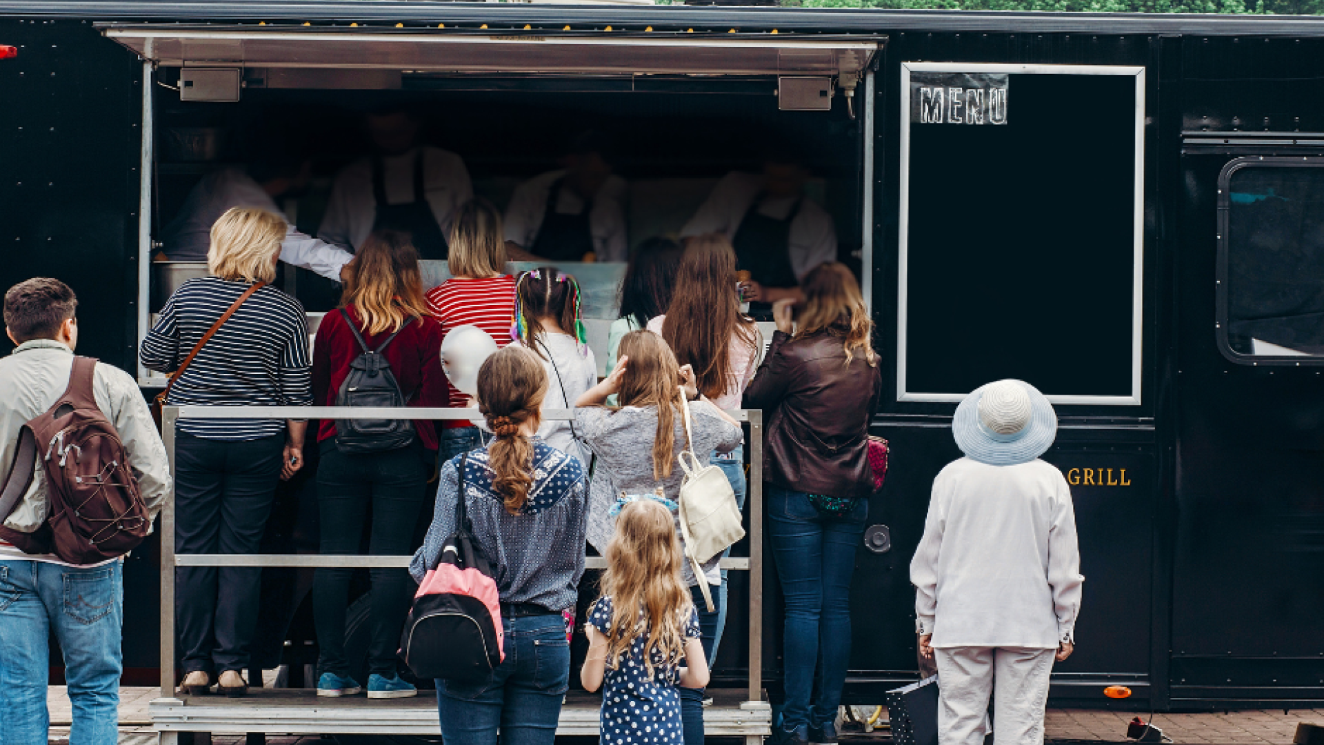 People standing in line for a food truck.