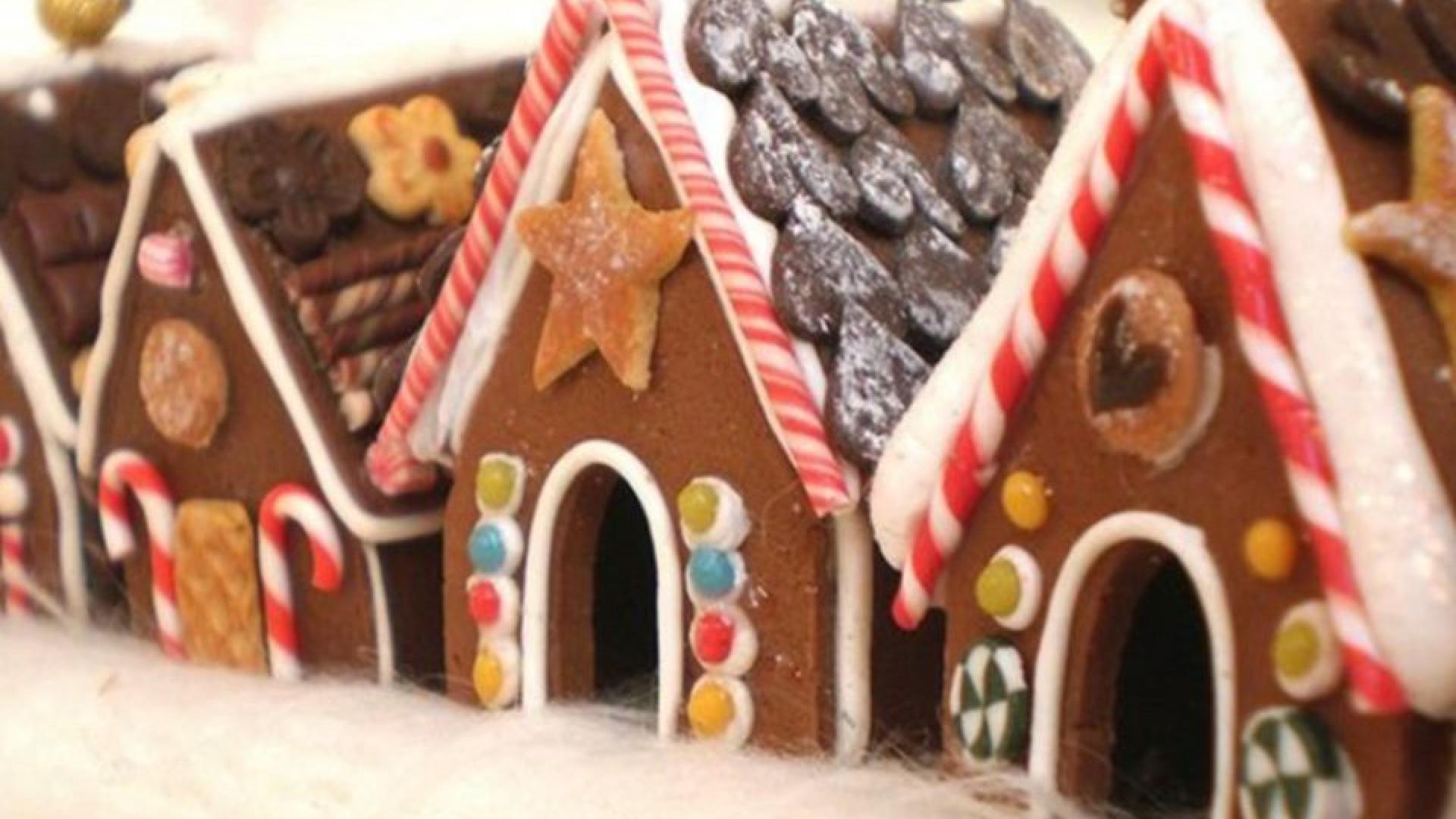 A row of gingerbread houses decorated with candy canes and colorful jellybeans.