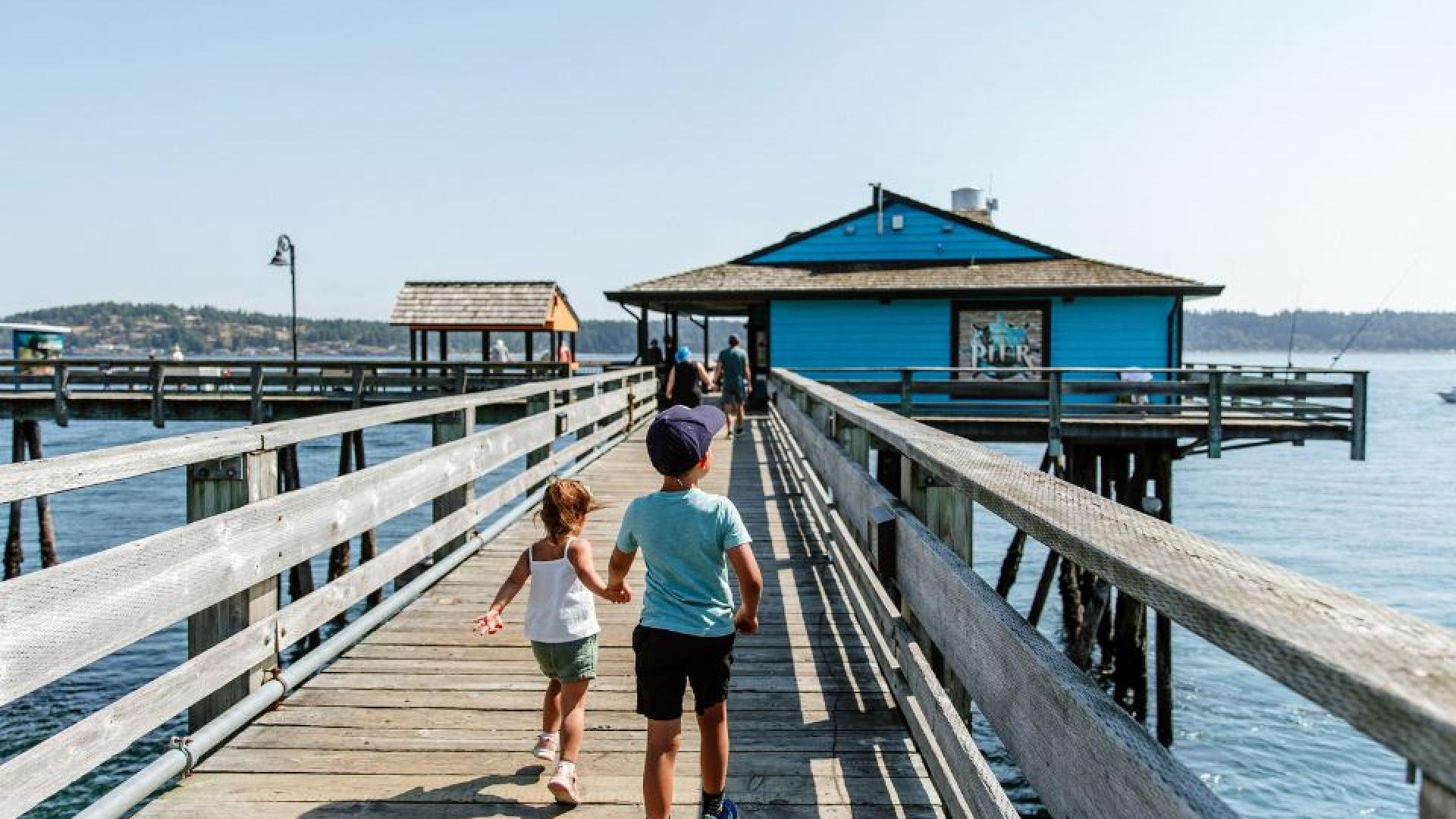 Two children run down the walkway towards the Campbell River Pier.