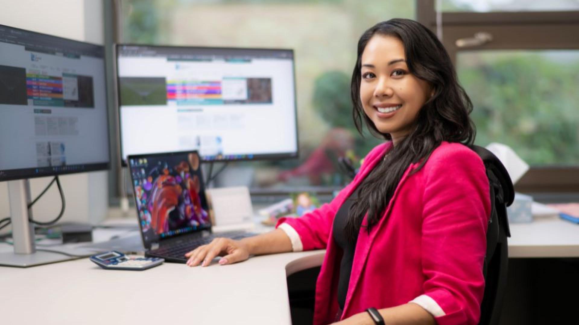 Smiling employee working at their desk in an office setting.