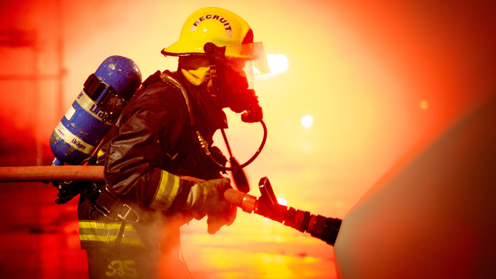A firefighter training with a fire hose.