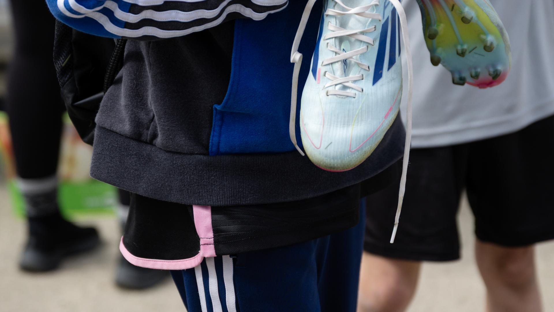 Soccer player holding cleats