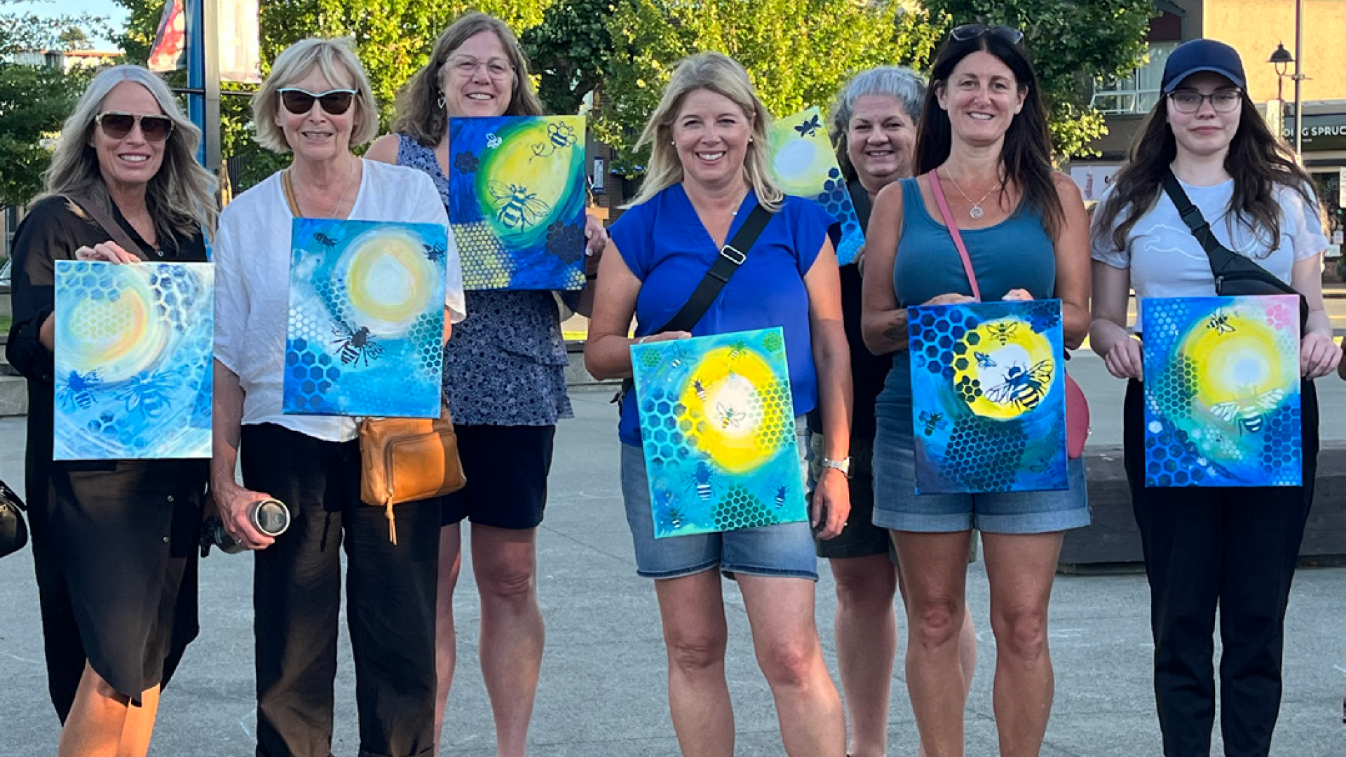 People standing in Spirit Square with their paintings.