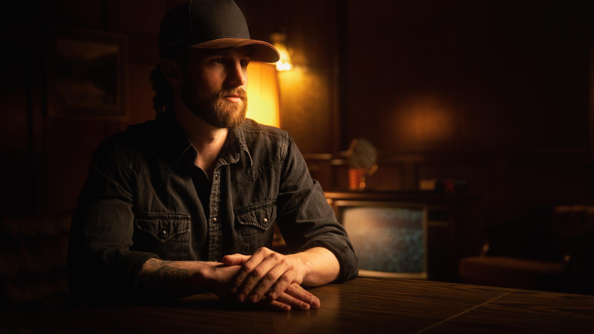 Mitch Zorn sits at a table under a dimly lit light.
