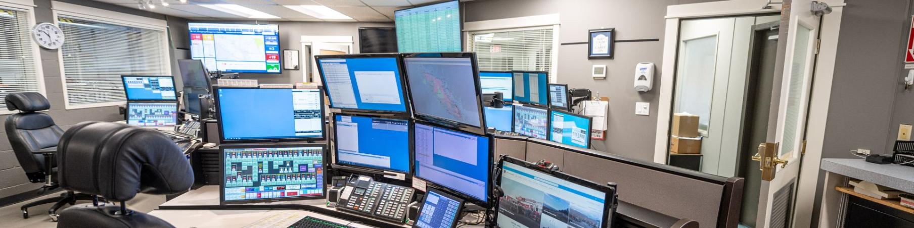 The Campbell River fire dispatch office filled with multiple computer screens and organized workstations, reflecting a high-tech environment for coordinating fire services.