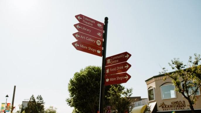 A signpost points out various shops, restaurants and other organizations and businesses in downtown Campbell River. The photo was taken by Bluetree Photography.