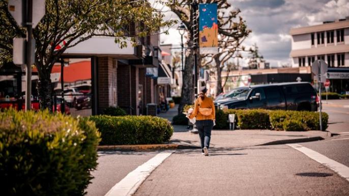 A person walks past shops and businesses in downtown Campbell River. The photo was taken by Bluhen Photography.
