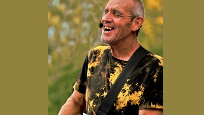 David Gauci singing and playing guitar.