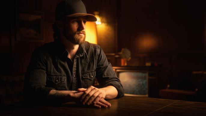 Mitch Zorn sits at a table under a dimly lit light.