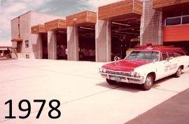 A vintage ambulance parked outside a fire station, 1978.