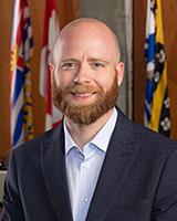 Ben Lanyon, a member of the Council, poses for a photo in a portrait-style format.