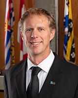 Sean Smyth, a member of the Council, poses for a photo in a portrait-style format.