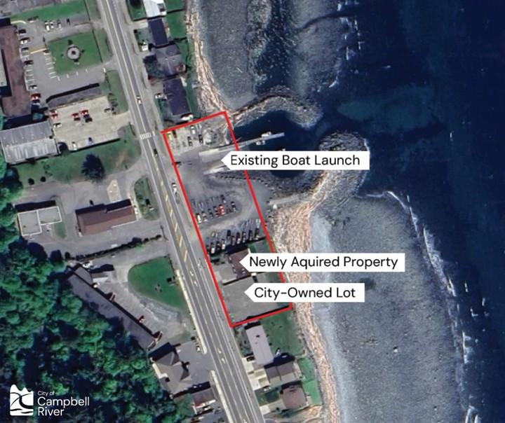 An aerial view of Campbell River shows the project area for upcoming improvement work at Big Rock Boat Ramp in Campbell River. Land is on the left side and the waterfront and ocean are on the right side of the image. A red border marks off the project area, with arrows and text identifying the existing boat launch, the newly acquired property and a City-owned lot. The City's logo is in the bottom-left corner.