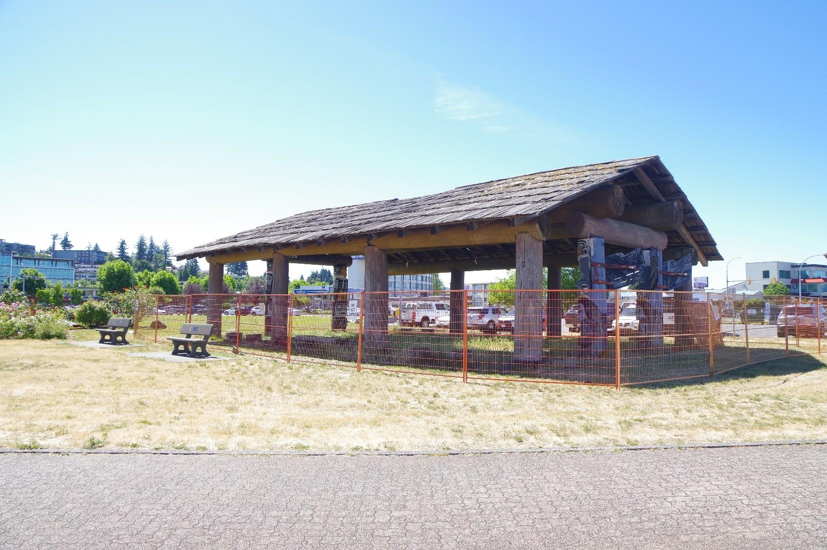 Foreshore Pavilion at Robert Ostler Park following a blessing ceremony. Orange fencing around the wooden pavilion indicates that the pavilion is closed to the public for safety reasons.