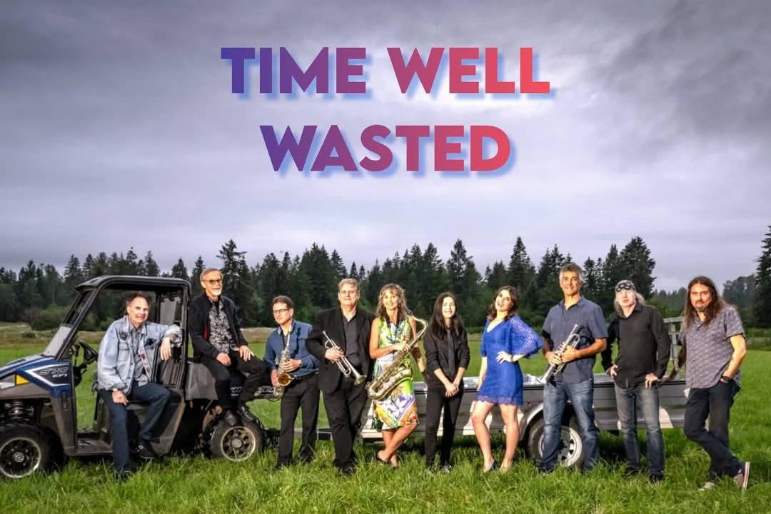 The band Time Well Wasted poses on a grassy lawn with trees and a cloudy sky in the background. The band's name is written across the sky. The photo was provided by Time Well Wasted.